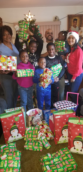 Our staff together with a family with five children, all holding their Christmas gifts