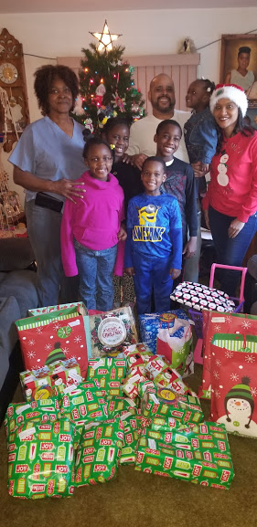 Our staff together with a family with five children and piles of gifts on the floor