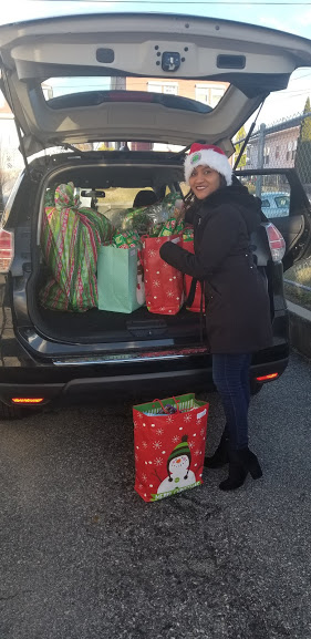 One of our female staff getting gifts from a car trunk