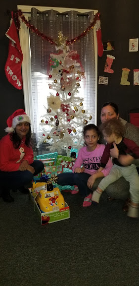 Our female staff together with a woman and her two children with a toy car and a white Christmas tree, 2