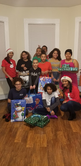 Two of our female staff and a group of children holding gifts, 2