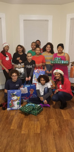Two of our female staff and a group of children holding gifts