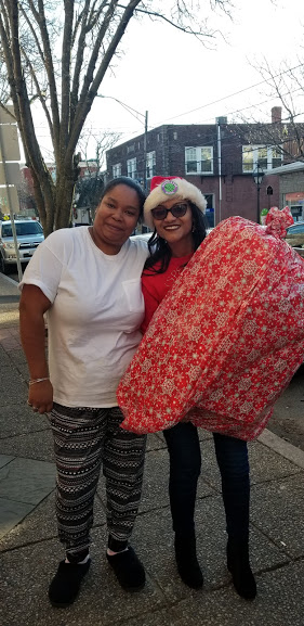 Our staff in red shirt carrying a big Christmas gift and another woman