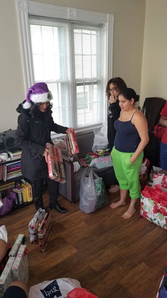Three women preparing the bags of gifts in a living room