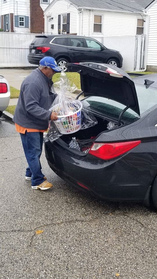 A man getting baskets from a trunk of a car