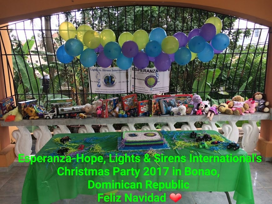 Green table with cake and toys and balloons displaced at the back; Christmas Party 2017 in Bonao