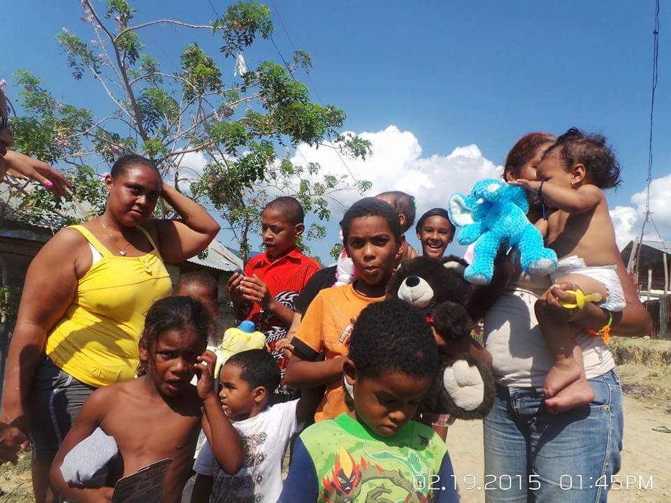 A big group of children with toys and two women