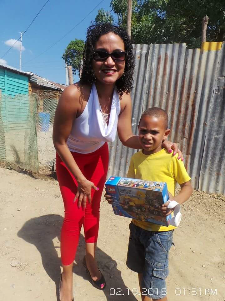 A woman in a white top and a boy holding a toy truck box