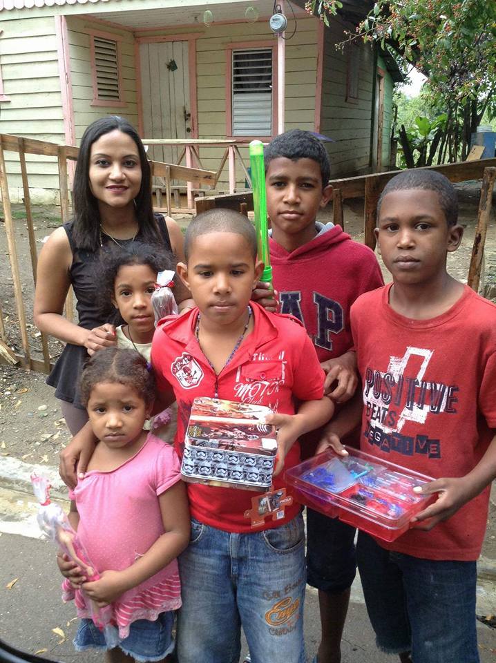 Our staff together with two girls and three boys in red shirts holding toys