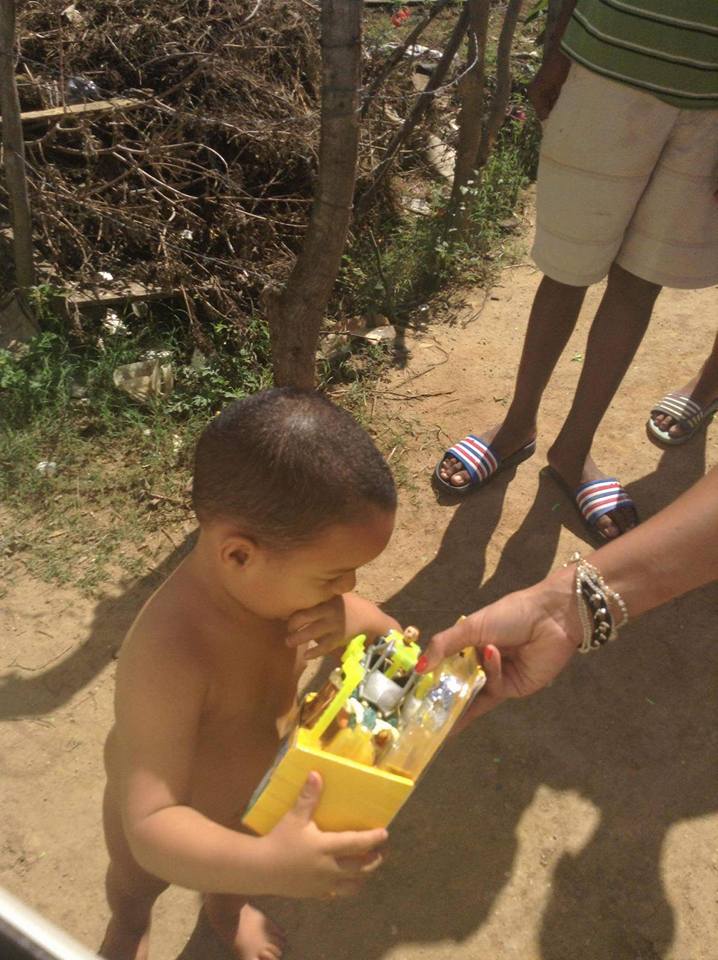 A naked child receiving a toy