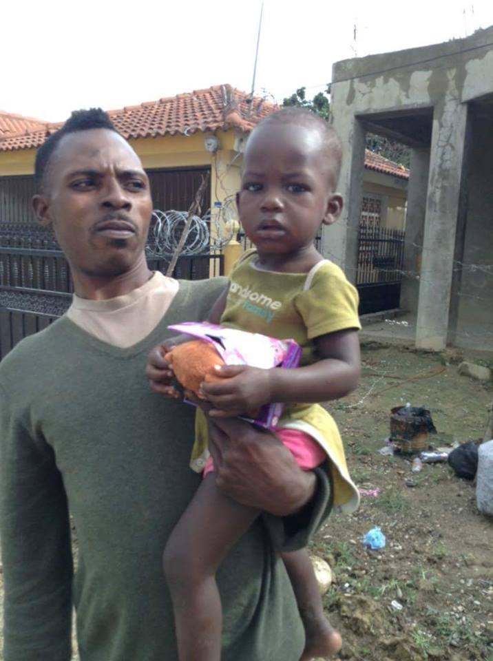 A man carrying a child who is holding a toy