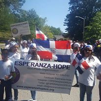 People holding Esperanza-Hope banner at the front and the others holding the Dominican Republic flag