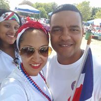 Two female and one male staff with one of them holding the Dominican Republic flag