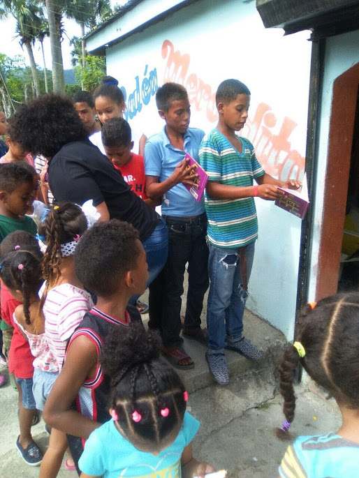 The children in line receiving books