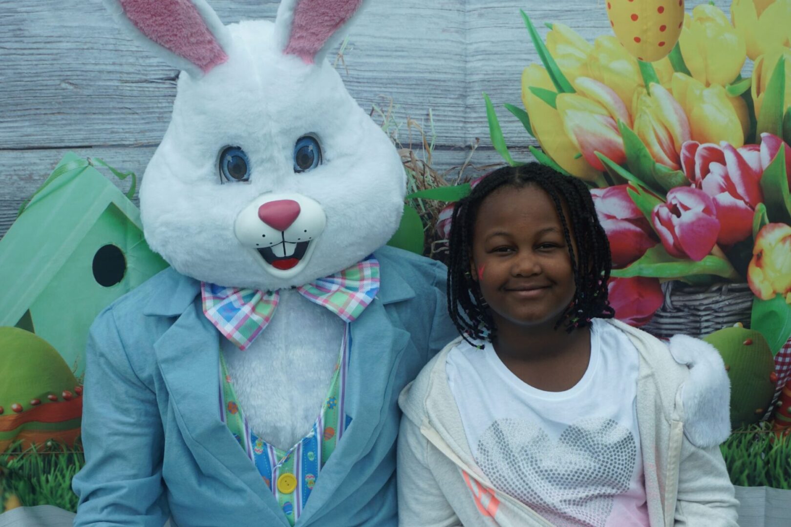 The bunny mascot with his arm around a girl in a thin jacket
