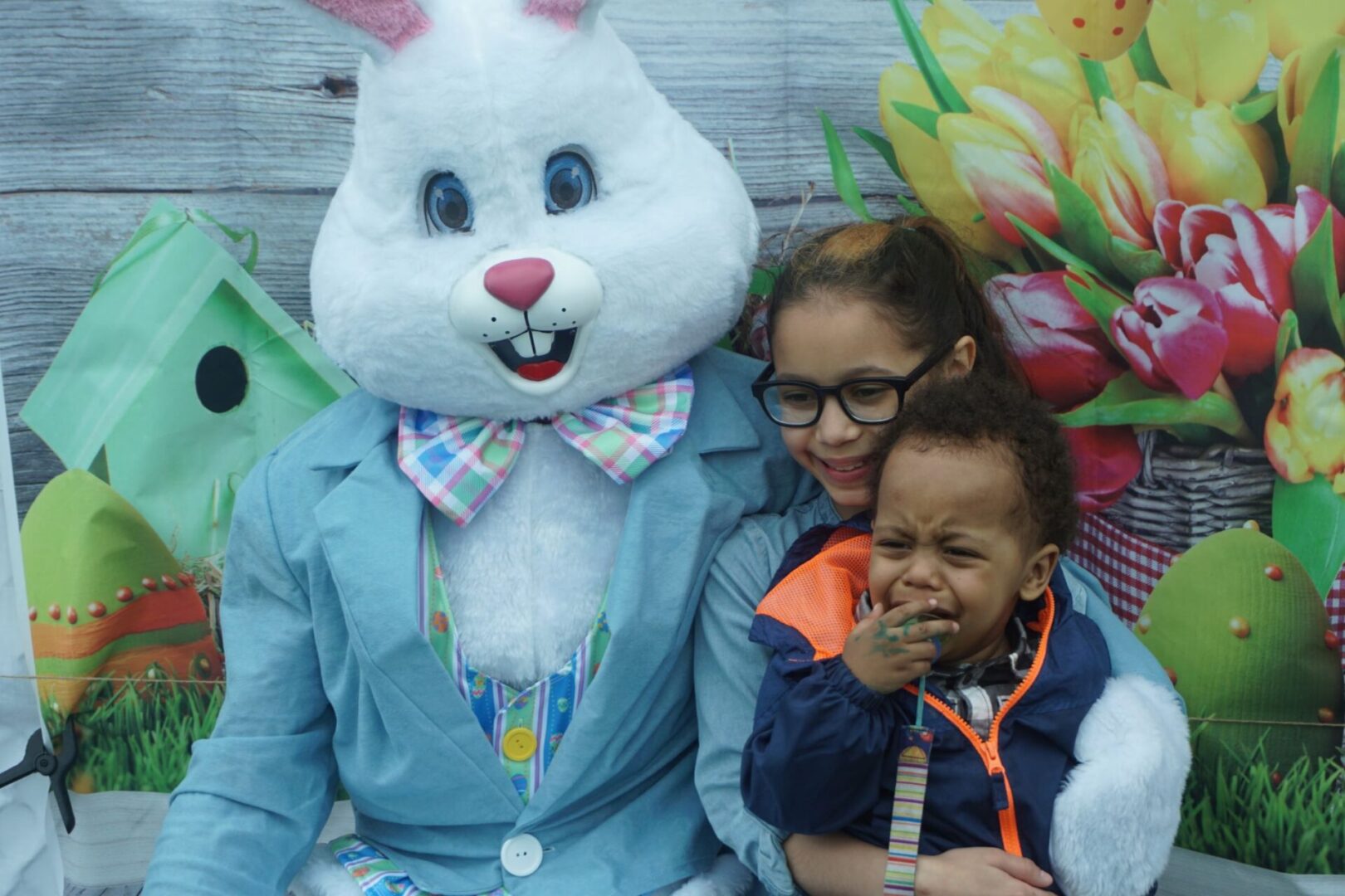 The bunny mascot and a girl with glasses carrying a crying boy