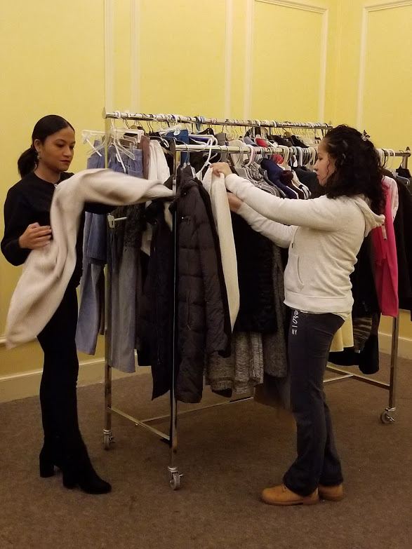 Two of our female staff hanging clothes on the rack
