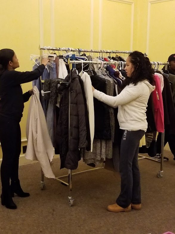 Two of our female staff hanging clothes on the rack, 2
