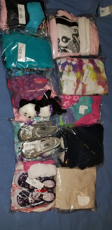 Various clothes and shoes in their plastic package