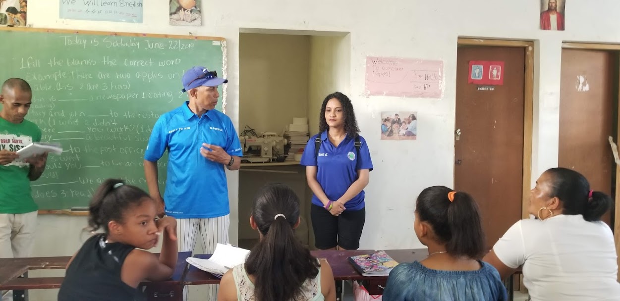 A man in blue cap talking in front of the classroom