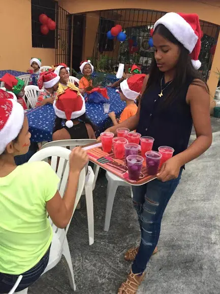 A woman serving juice for the children