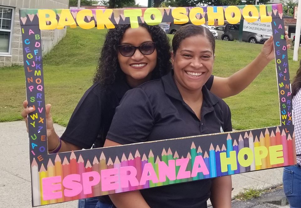 Two female staff smiling and holding a back to school frame