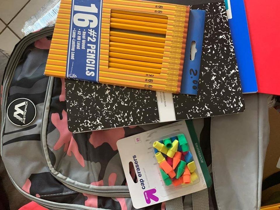 A pink and gray camouflage-designed bag, notebooks, a box of pencils, and a pack of cap erasers (1)