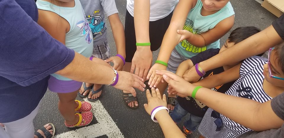A group of children showing their purple and green wristbands