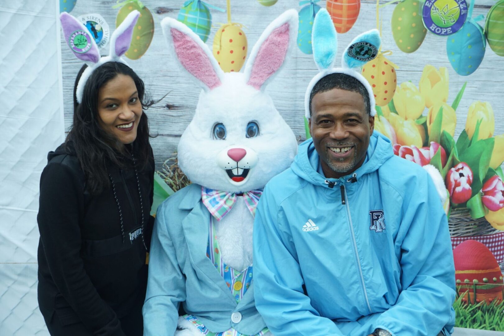 The bunny mascot and a male and female staff wearing bunny ears