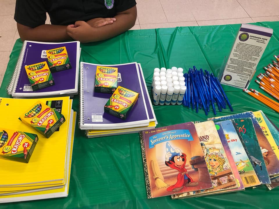 Green table of school supplies and some brochures of Esperanza-Hope