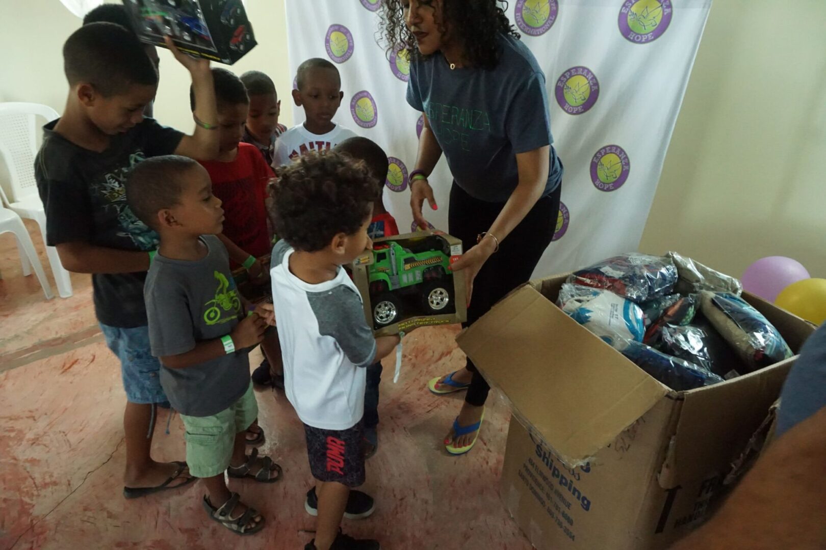 Boys line up to receive toys from our staff, different view