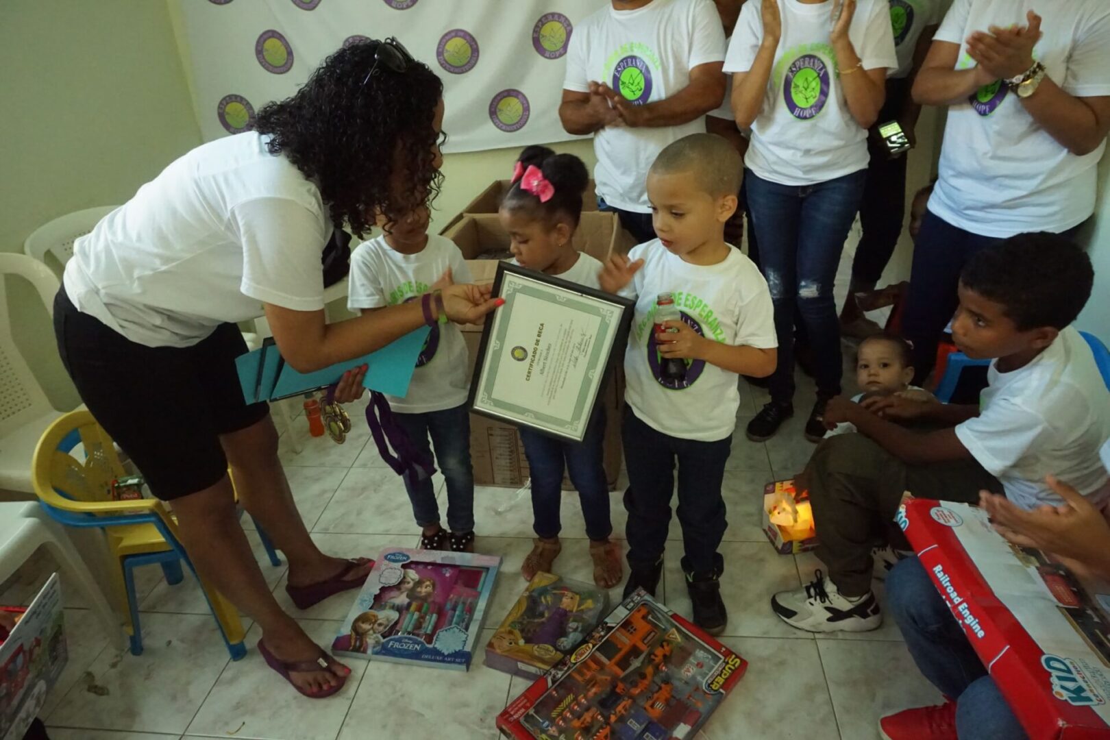 A female staff giving the children a certificate