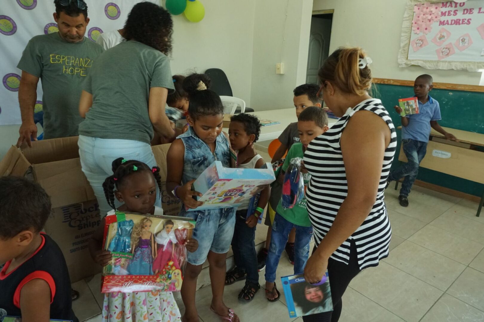 Staff working at the back and a group of children holding toys