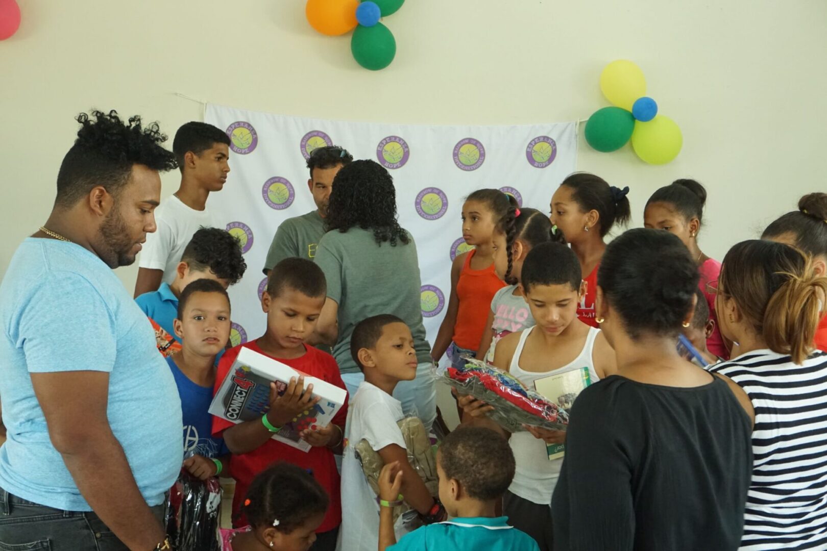 Our staff talking at the back and a group of children holding and looking at their toys