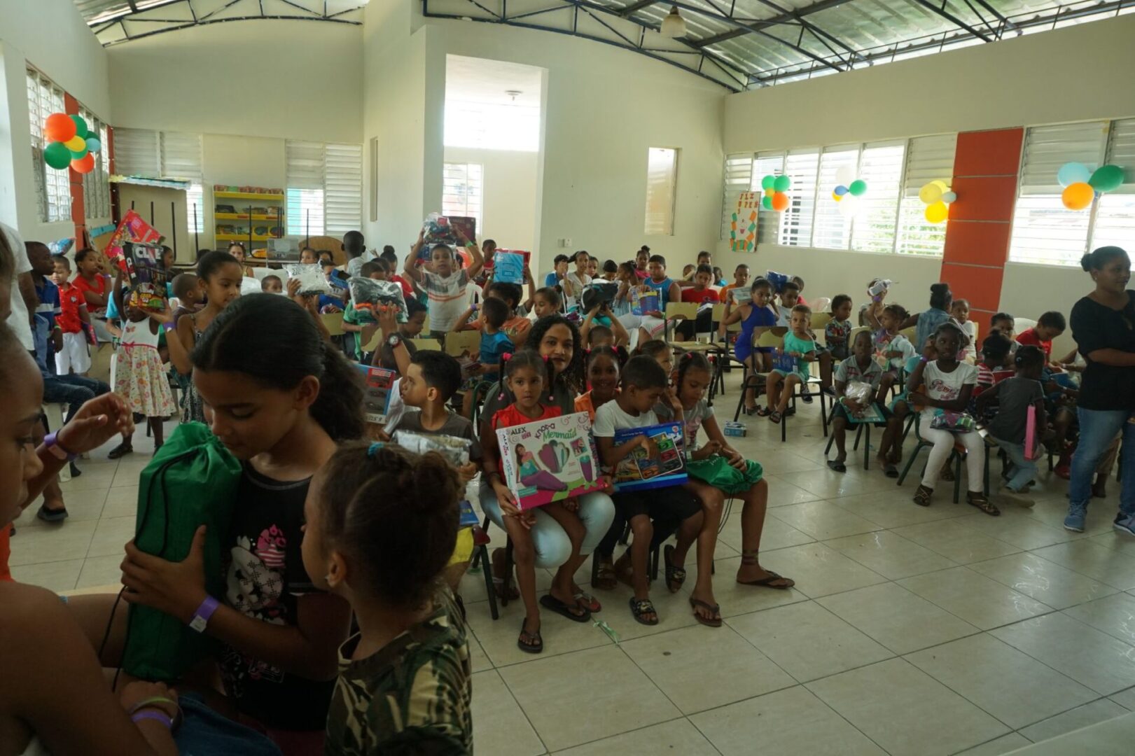 A classroom full of children sitting on the chairs and holding their toys (scaled)