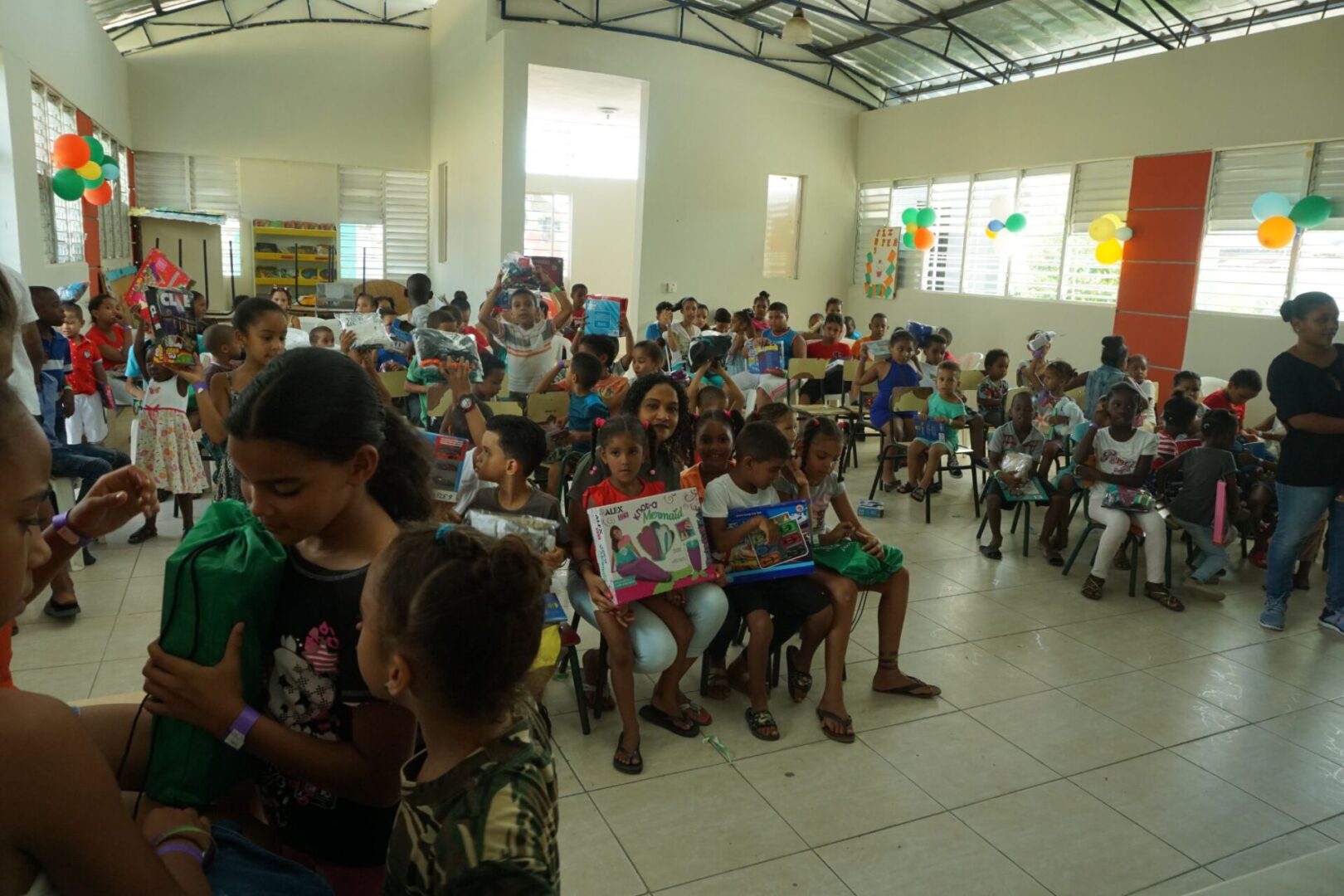 A classroom full of children sitting on the chairs and holding their toys