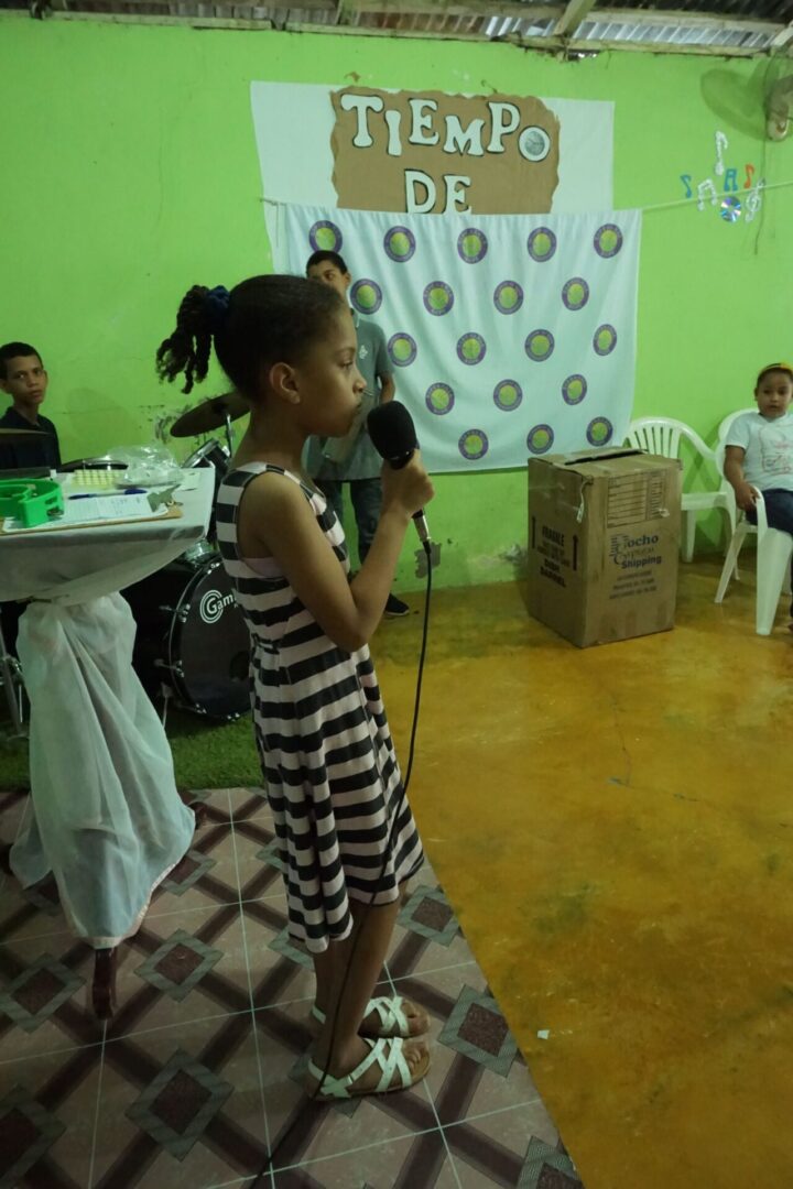 A girl in a dress holding a mic