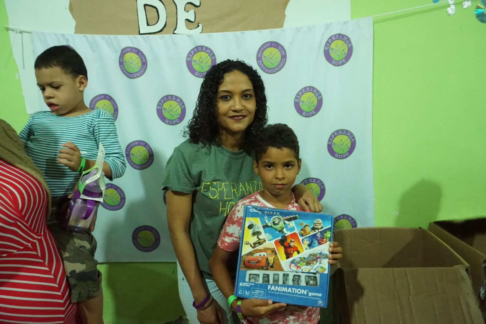 A staff and a child holding a box of toy