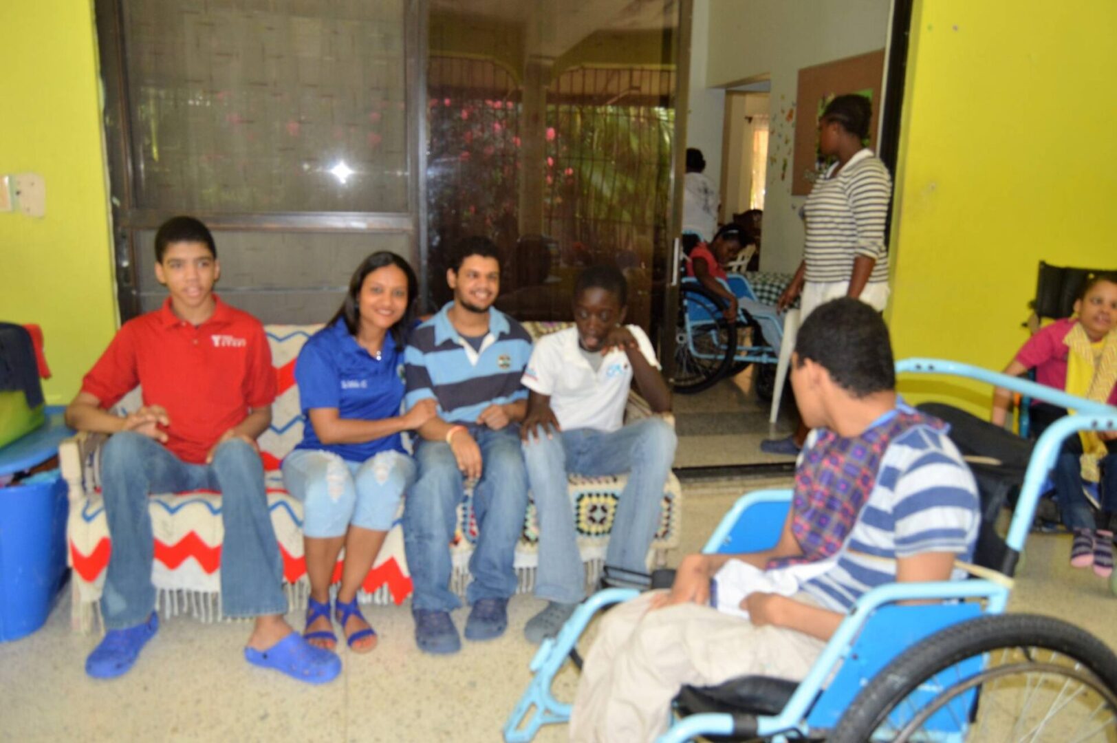 Our female staff sitting together with some of the disabled children from Casa Nazaret and another boy in a wheelchair
