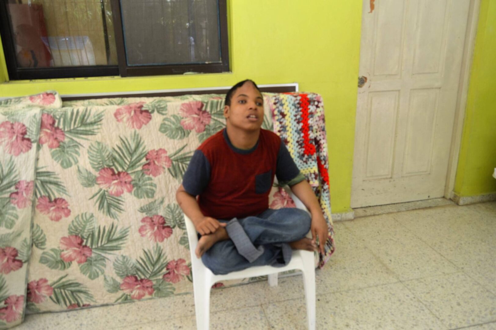 A boy sitting cross-legged in a chair