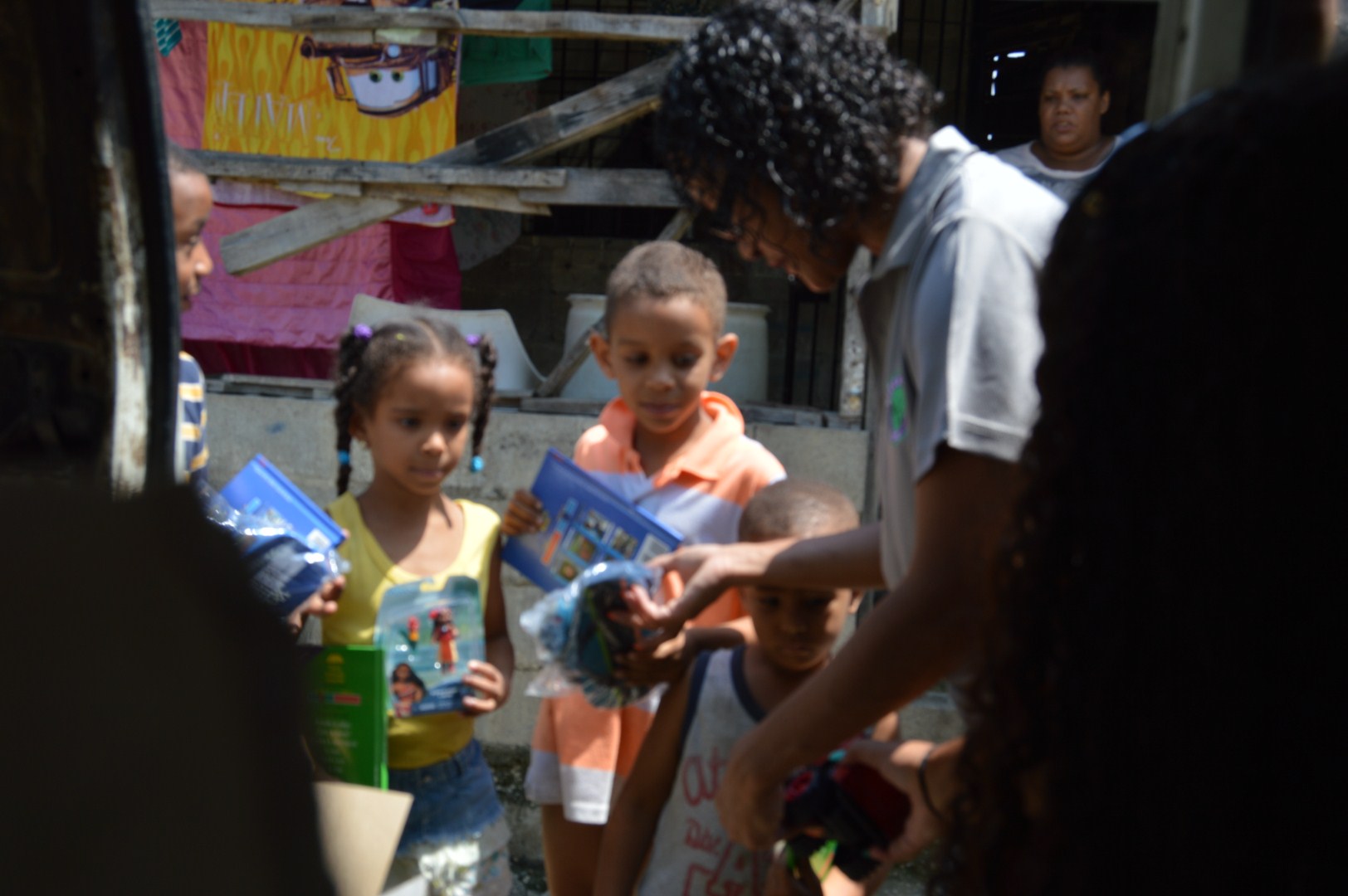 Our staff giving out toys to the children outside the house