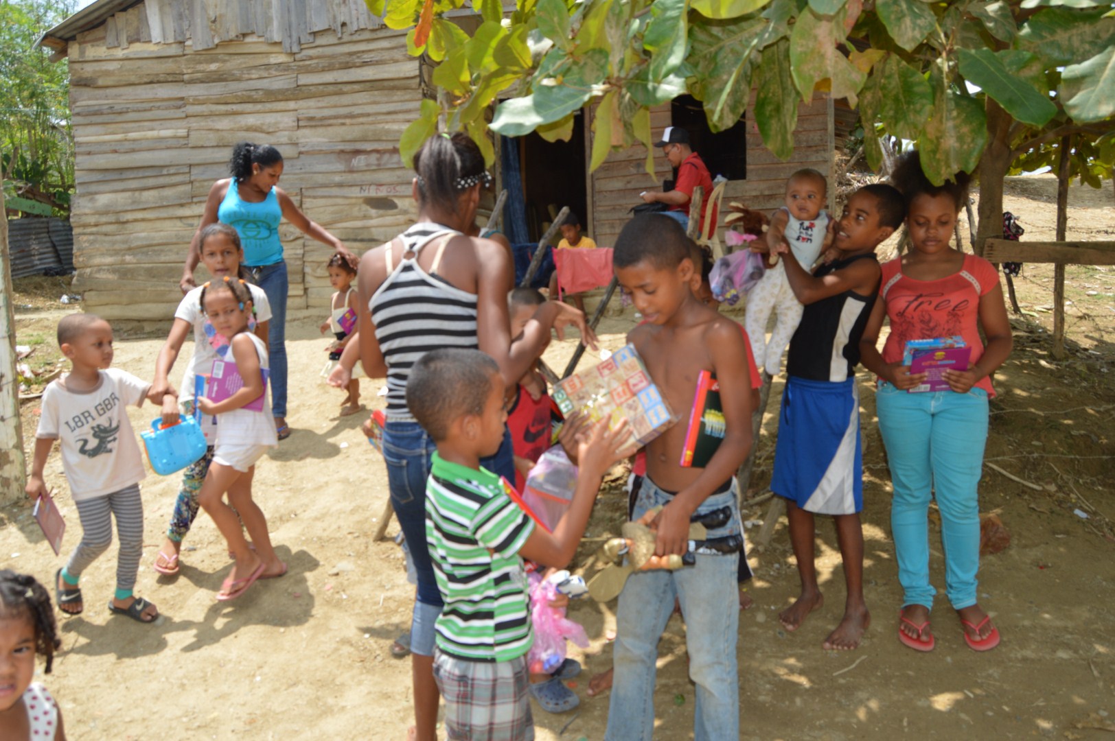 Children showing and playing with their toys outside under the shade of a tree
