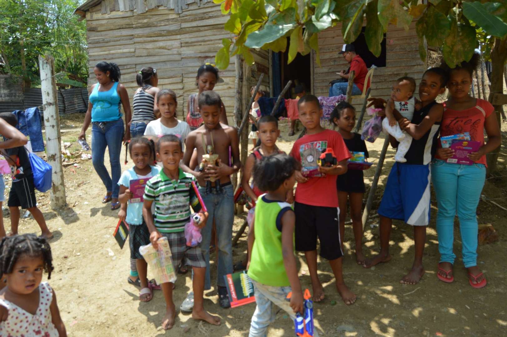 A group of children under a tree holding their books and toys, version 2