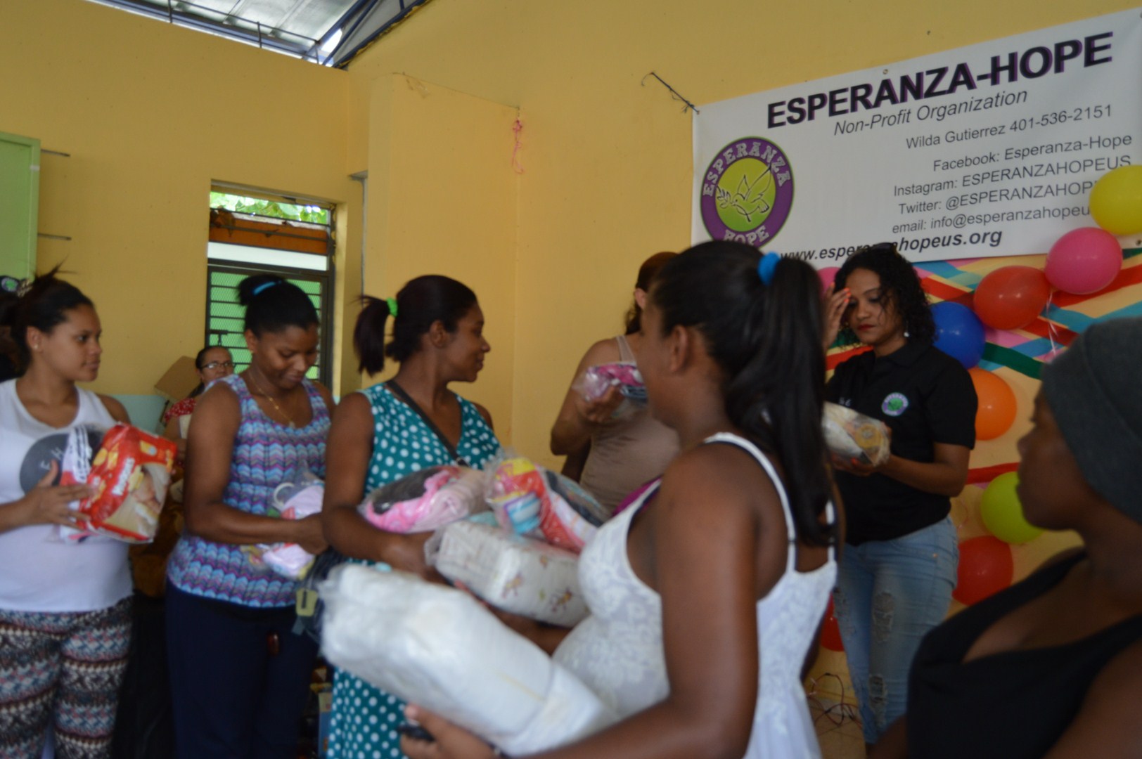 Mothers receiving packs of diapers and clothes