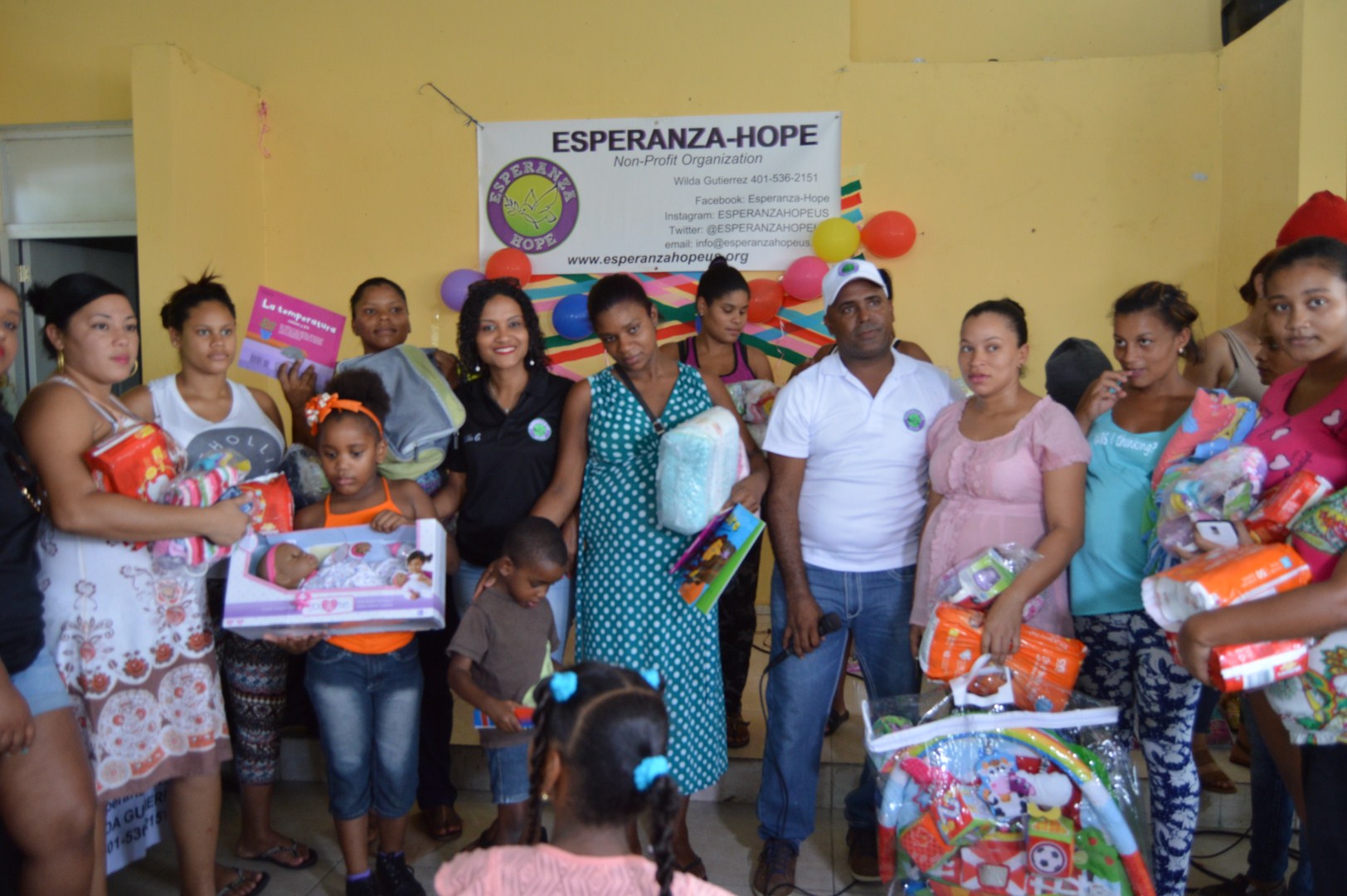 The mothers and some of their children holding toys, diapers, and clothes