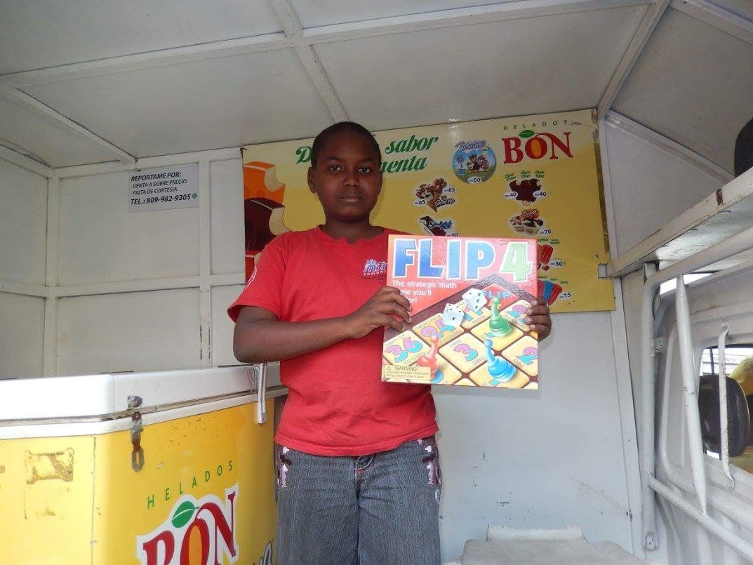 A boy holding a box of Flip 4 board game