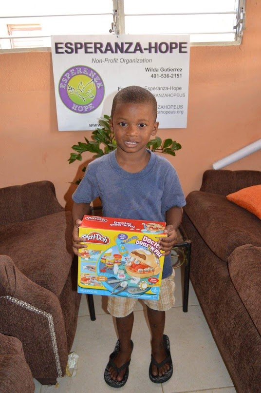 A boy smiling and holding a Play-Doh box