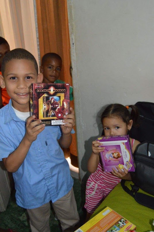 Two children smiling and showing off their boxes of toys
