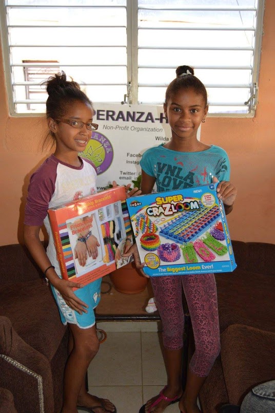 Two girls each holding a box of bracelet making kits