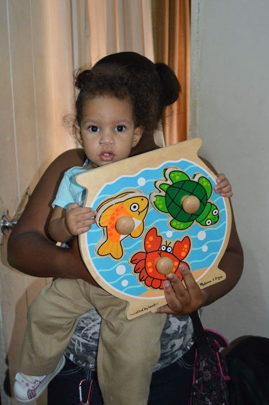 A baby holding a toy with sea creatures
